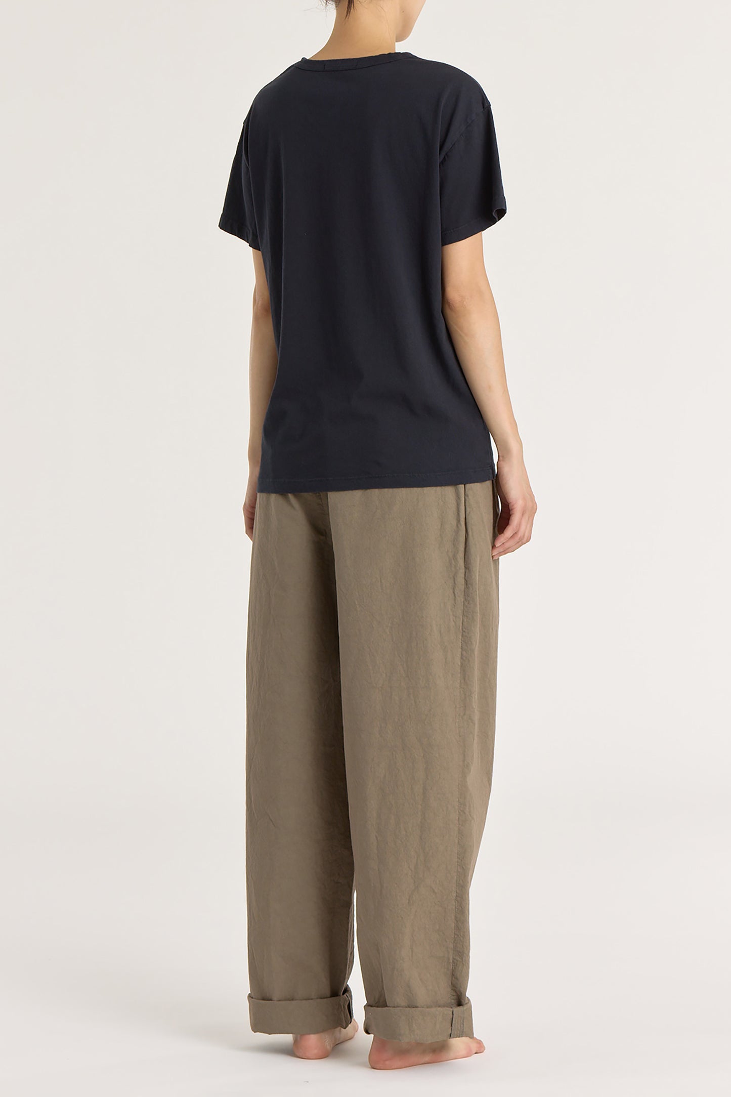 A person wearing a black short-sleeved crew neck t-shirt.