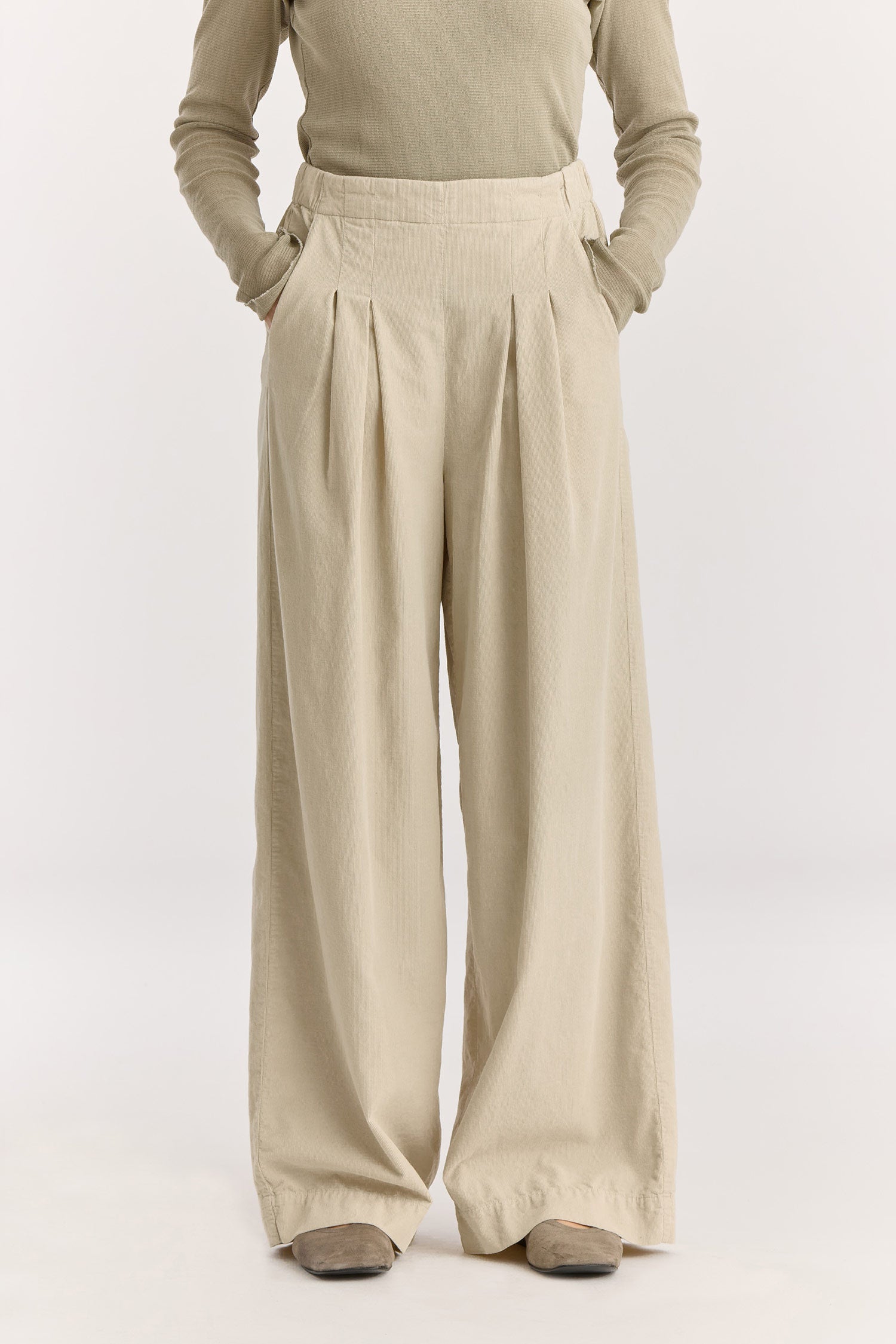 Wide Pleated Pants / Ivory
Elastic waist
Pleated detail at the front
Slash pockets
Wide shape
100% Cotton baby corduroy
Machine wash in cold water, tumble dry low, no bleach
Style number: BC-LWP05
Regular fit
Made in USA
Woman wearing ivory wide-leg baby corduroy pants with front pleats, elastic waistband, and slash pockets.