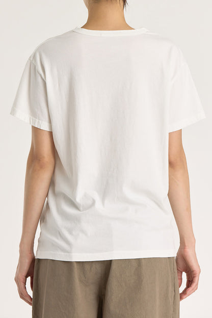 A person wearing a white regular short sleeve tee and brown pants. The tee has a crew neck and short sleeves.